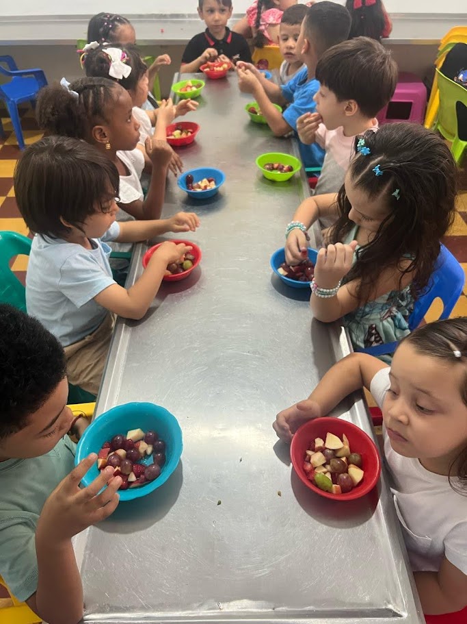 Niños compartiendo frutas en el comedor