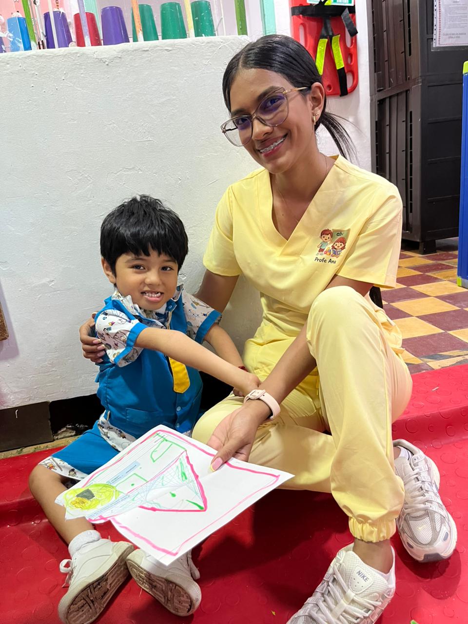 Niñera de Mi Casita del Saber con niño en actividad artística