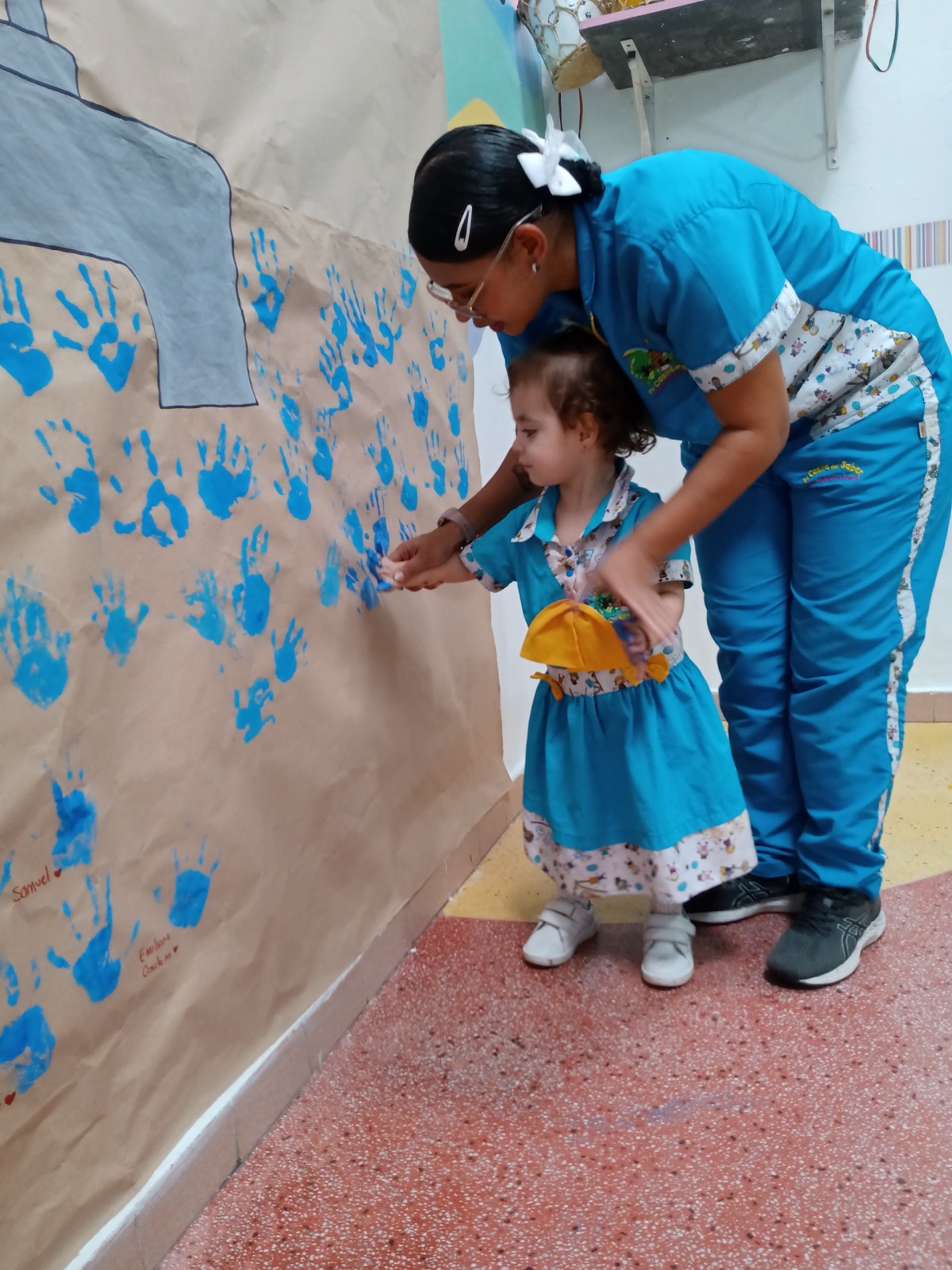 Profesora acompañando a niña en actividad artística