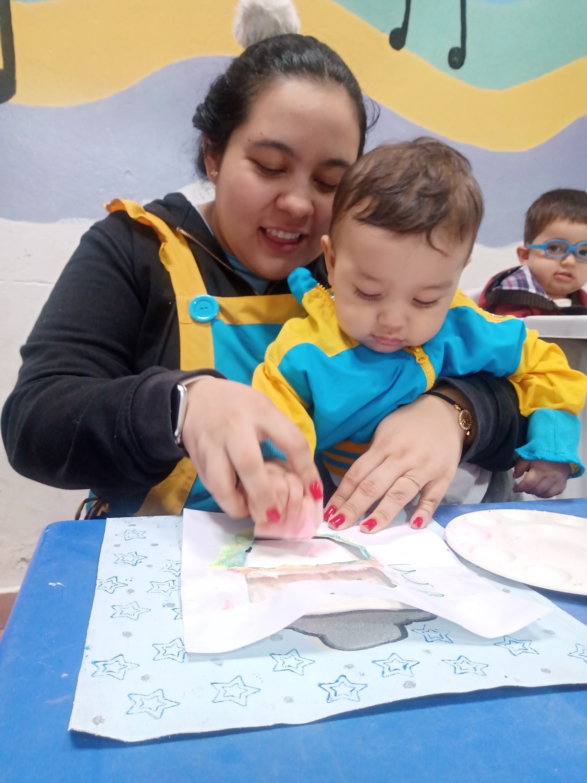 Profesora haciendo arte con bebé